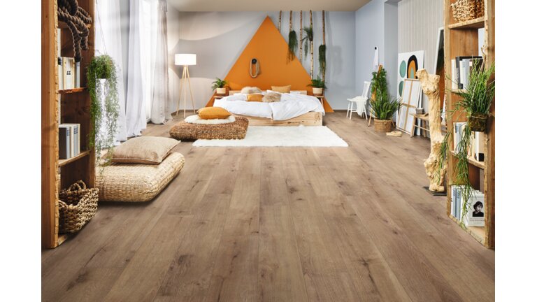 Gemütliches Schlafzimmer mit warmem Parkettboden in Eichenoptik.